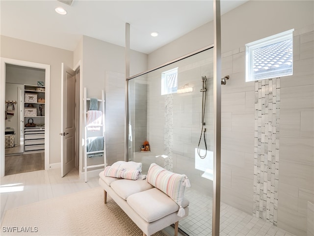 bathroom featuring tile patterned flooring, a wealth of natural light, and tiled shower