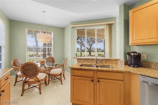 kitchen with light brown cabinets, light stone counters, light tile patterned floors, stainless steel dishwasher, and sink