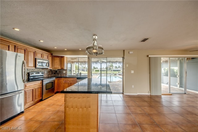 kitchen featuring a center island, stainless steel appliances, a healthy amount of sunlight, and tasteful backsplash