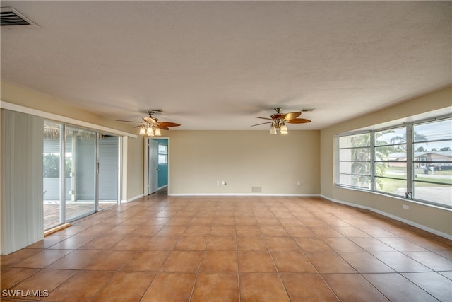 tiled spare room featuring a textured ceiling and ceiling fan