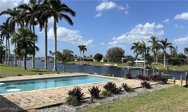 view of pool with a water view and a lawn