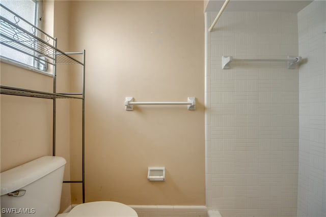 bathroom with toilet and a tile shower