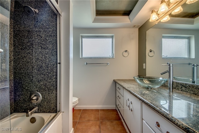 full bathroom with vanity, toilet, a raised ceiling, and a wealth of natural light