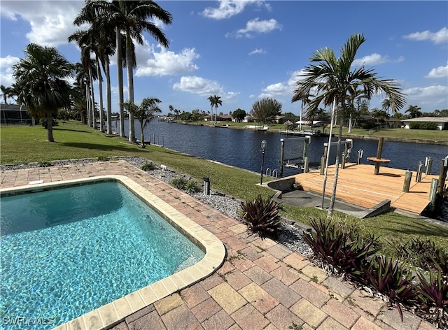 view of pool with a boat dock, a lawn, and a water view