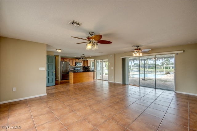 unfurnished living room featuring ceiling fan and light tile patterned floors