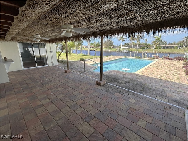 view of pool with a water view, a patio area, and ceiling fan