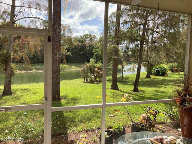 sunroom / solarium featuring a water view