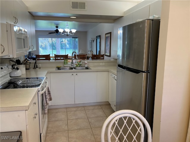 kitchen with white appliances, light tile patterned floors, visible vents, light countertops, and a sink