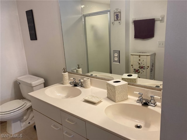 bathroom featuring a stall shower, a sink, toilet, and double vanity