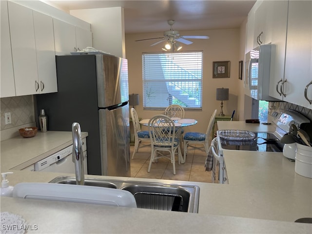 kitchen featuring white appliances, white cabinets, decorative backsplash, light countertops, and light tile patterned flooring