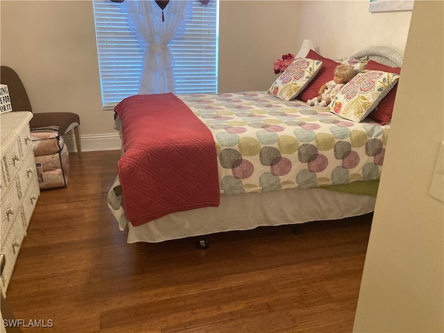 bedroom featuring wood finished floors and baseboards