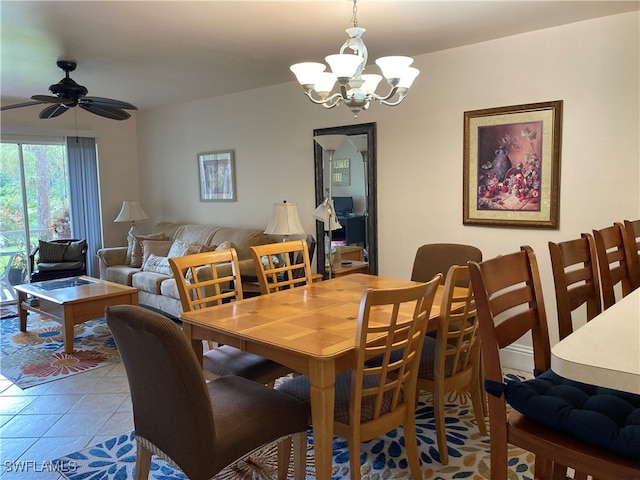 tiled dining room with ceiling fan with notable chandelier