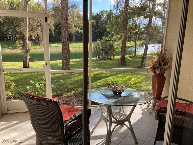 sunroom / solarium featuring a water view