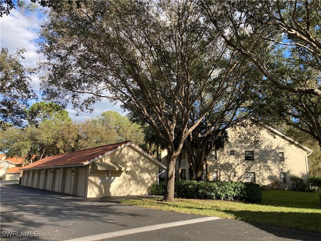 view of side of property with a lawn and community garages