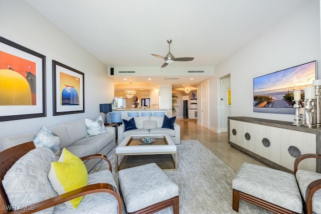 living room featuring ceiling fan with notable chandelier