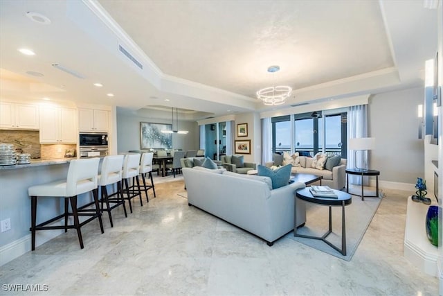 4851 Bonita Bay Blvd Unit 2203, Bonita Springs, FL 34134 - living room featuring visible vents, a chandelier, crown molding, a raised ceiling, and baseboards