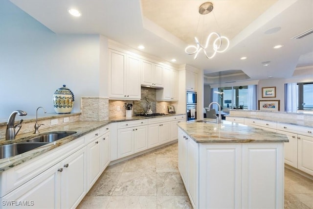 4851 Bonita Bay Blvd Unit 2203, Bonita Springs, FL 34134 - kitchen featuring stainless steel appliances, tasteful backsplash, a raised ceiling, and a sink