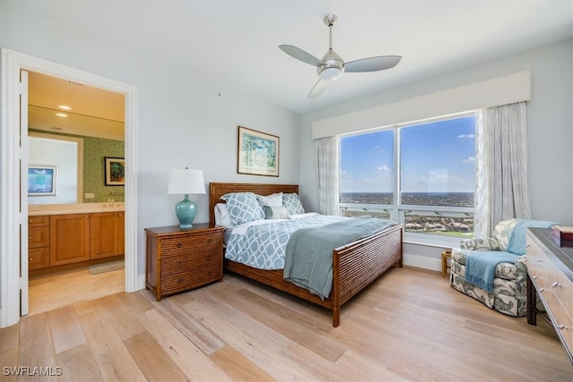 bedroom featuring ensuite bathroom, light wood-type flooring, and ceiling fan