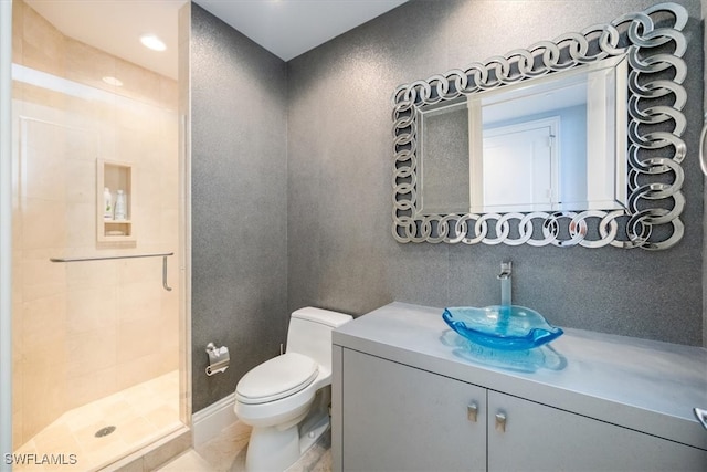 bathroom with a shower with shower door, vanity, toilet, and tile patterned floors