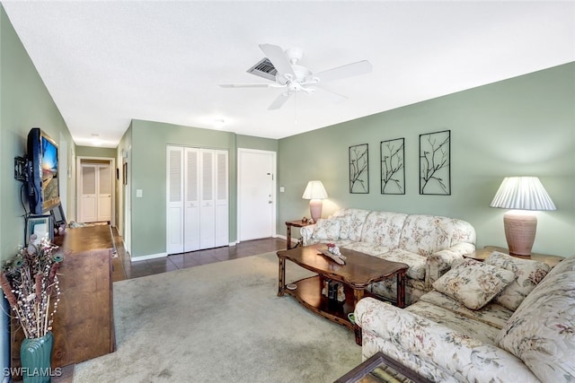 living room with ceiling fan and dark colored carpet