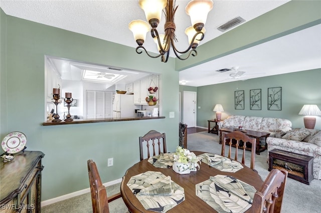 dining area featuring a textured ceiling, carpet floors, ceiling fan with notable chandelier, and a skylight