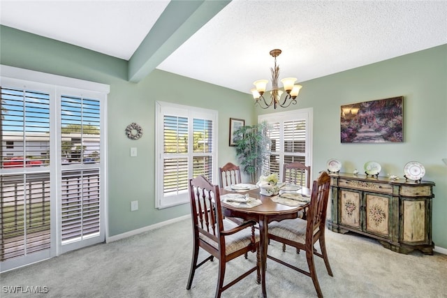 dining room with a textured ceiling, a notable chandelier, and light colored carpet