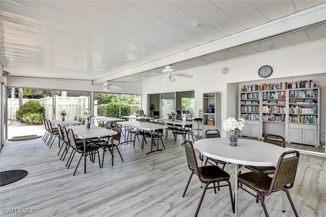 dining area with ceiling fan, beamed ceiling, and light hardwood / wood-style flooring