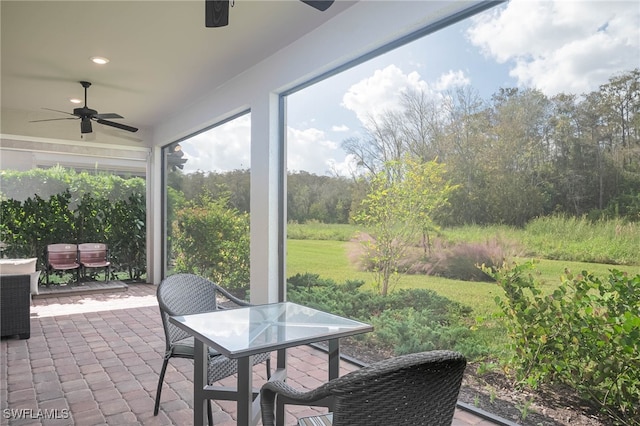 sunroom featuring ceiling fan