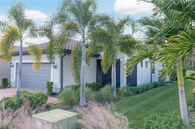 view of front of property featuring a front lawn and a garage