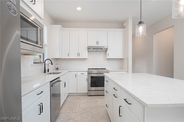 kitchen featuring tasteful backsplash, sink, stainless steel appliances, pendant lighting, and white cabinets