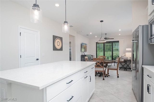 kitchen with white cabinets, decorative light fixtures, high end refrigerator, and a kitchen island