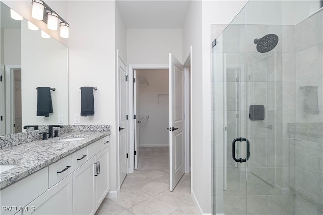 bathroom featuring vanity, tile patterned flooring, and a shower with door