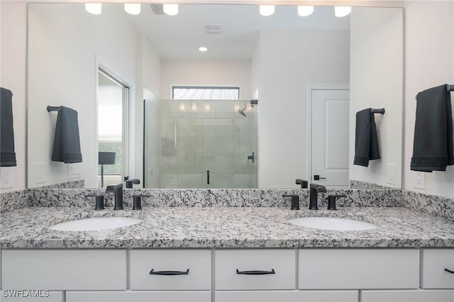 bathroom featuring vanity and a shower with door