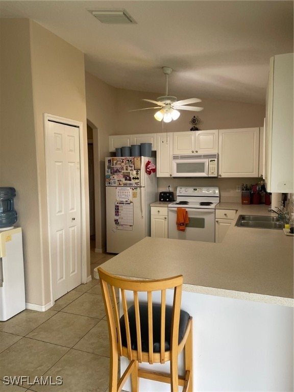 kitchen featuring white cabinets, sink, vaulted ceiling, and white appliances