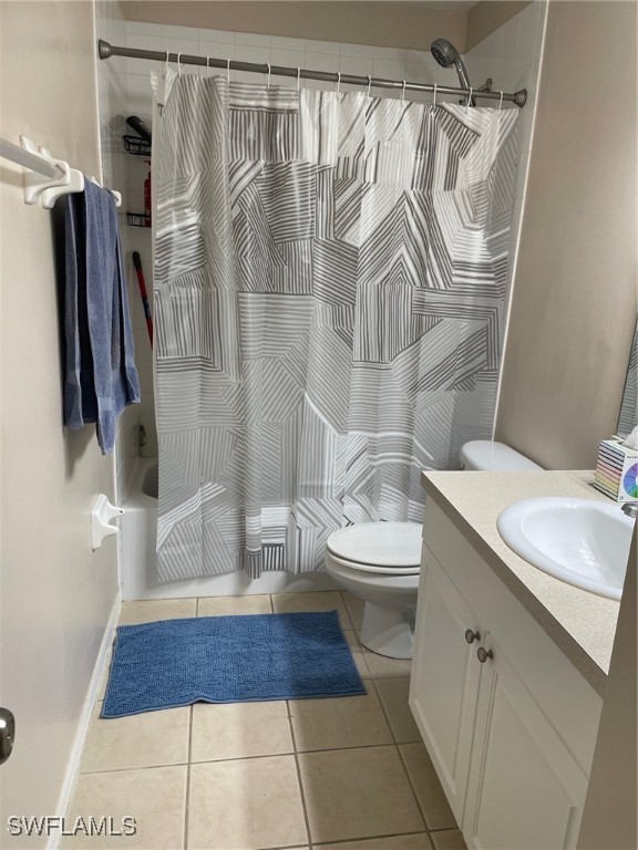 full bathroom with vanity, shower / bath combination with curtain, toilet, and tile patterned floors