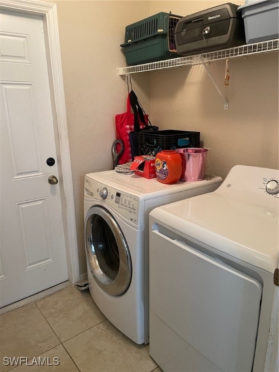 washroom with washing machine and dryer and light tile patterned floors