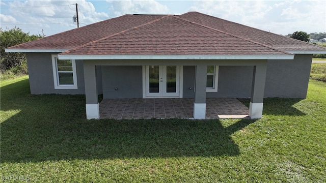 back of property with a lawn and a patio area