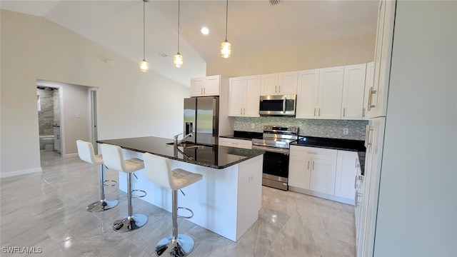 kitchen featuring a center island with sink, white cabinets, stainless steel appliances, and high vaulted ceiling