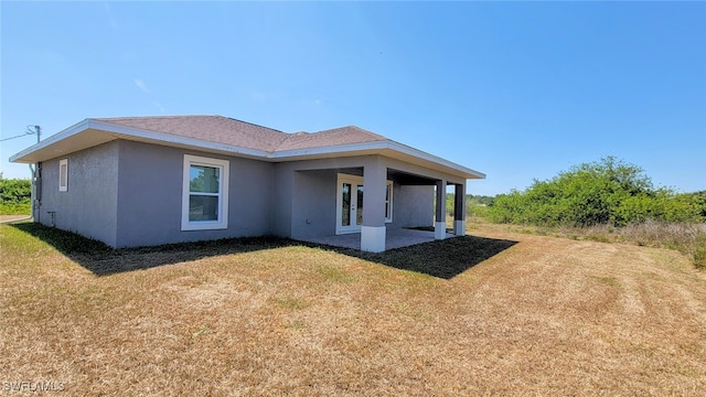 back of property featuring a lawn and a patio area