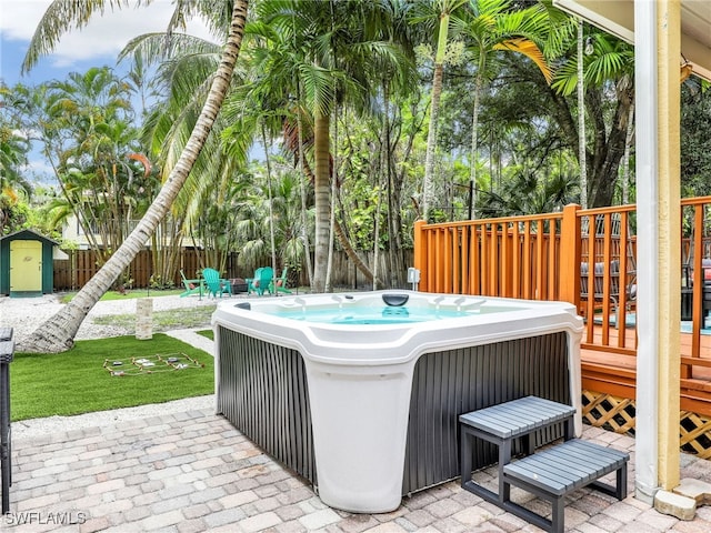 view of patio / terrace featuring a hot tub and a shed