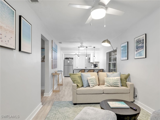 living room featuring light wood-type flooring and ceiling fan