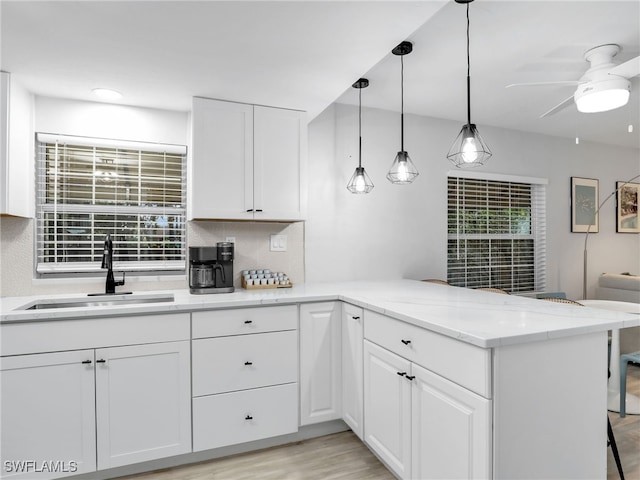 kitchen featuring white cabinetry, ceiling fan, sink, and kitchen peninsula