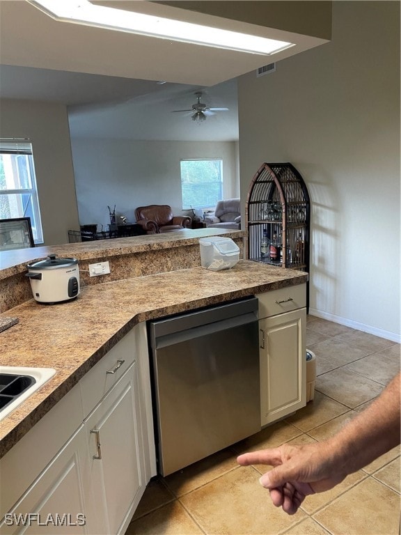 kitchen featuring light tile patterned flooring, a healthy amount of sunlight, stainless steel dishwasher, and ceiling fan