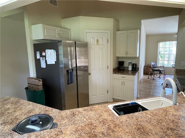 kitchen with white cabinetry, light tile patterned floors, sink, and stainless steel refrigerator with ice dispenser