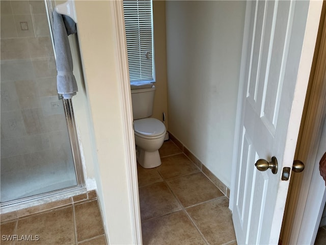 bathroom with tile patterned floors, toilet, and walk in shower