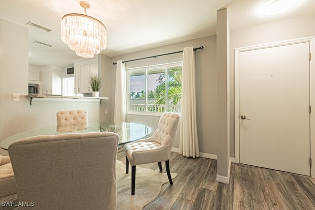 dining space featuring a notable chandelier and dark wood-type flooring