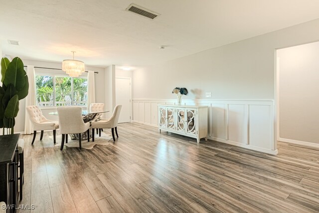 dining area featuring hardwood / wood-style flooring and a notable chandelier