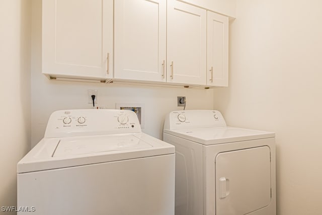 washroom featuring washer and clothes dryer and cabinets