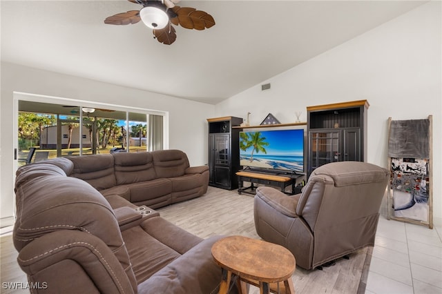 living room with ceiling fan, vaulted ceiling, and light tile patterned floors