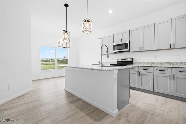 833 Newell St E, Lehigh Acres, FL 33974 - kitchen featuring stainless steel microwave, electric range oven, light wood-type flooring, gray cabinetry, and recessed lighting